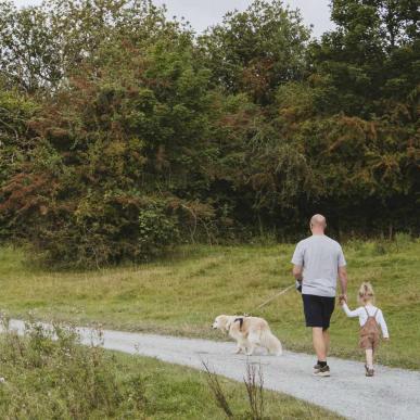 Familie med hund går tur ved stæren i madsbyparken